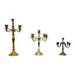Mismatched vintage brass 5-prong candelabras with varied heights, warm patina finish, styled for wedding tablescape