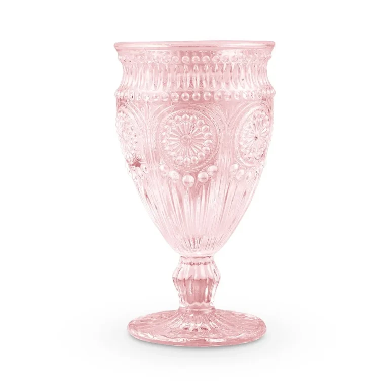 Blush pink embossed glass goblet with a sunflower style medallion pattern on a white background