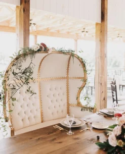 Tia gold canopy throne chair at wedding reception with floral table setting