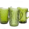 Vintage Olive Pitchers — mismatched olive green glass pitchers in varying shapes and heights, grouped on tabletop