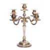Vintage mismatched silver 5-prong candelabras with varied finishes and silhouettes, styled for formal event setting