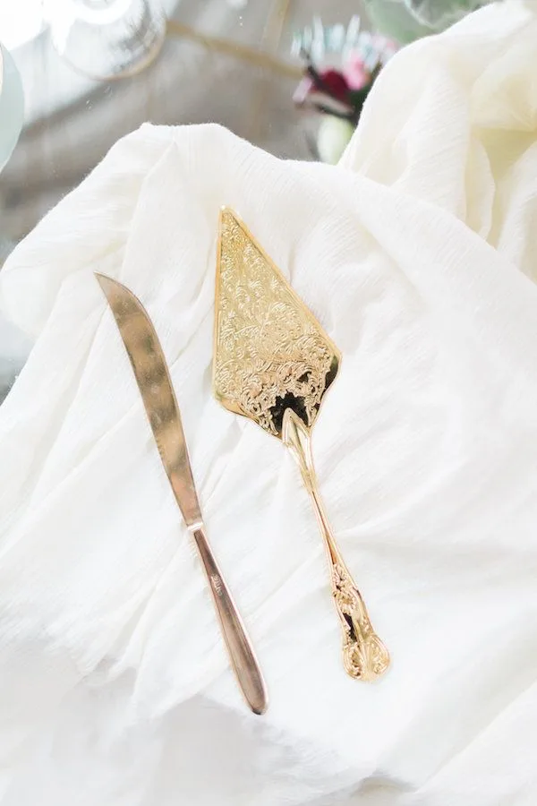 Gold cake server and knife WEBP Gold cake server and knife on white linen