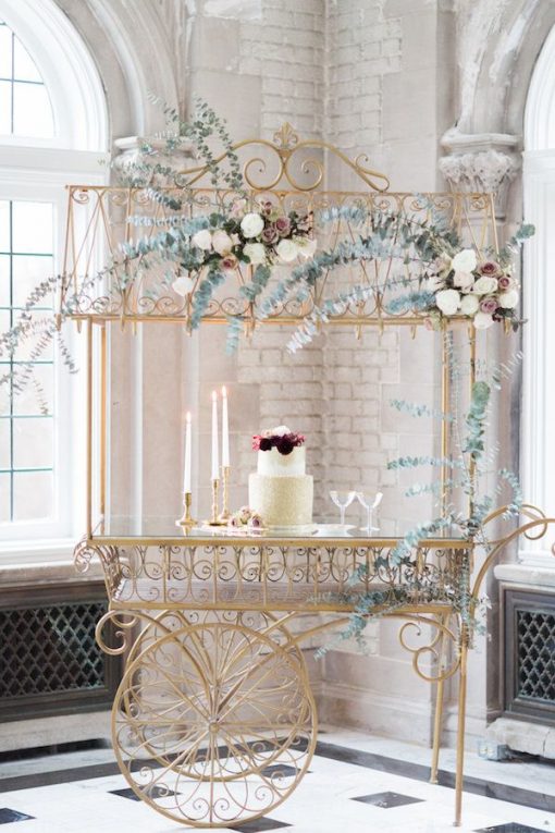 Our gold display cart with a cake and florals