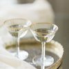 Two vintage glass coupes with gold rims on a mirrored gold tray