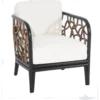 Trini Chair — boho-modern rattan accent chair with interlocking woven circular panels, curved black frame, and white cushions