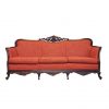 An orange-red vintage sofa with ornate dark wood edging and feet