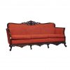 Orange/red vintage sofa with dark wood edges, feet, and top detailing. Side view