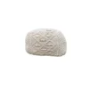 Ivory macrame pouf with geometric designs.