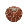 Brown leather Moroccan style pouf with white stitching creating geometic shapes along the sides and a snowflake like design in the center of the top.