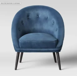 Accent chair with rounded back, button tufted, and velvet fabric. Brown legs.