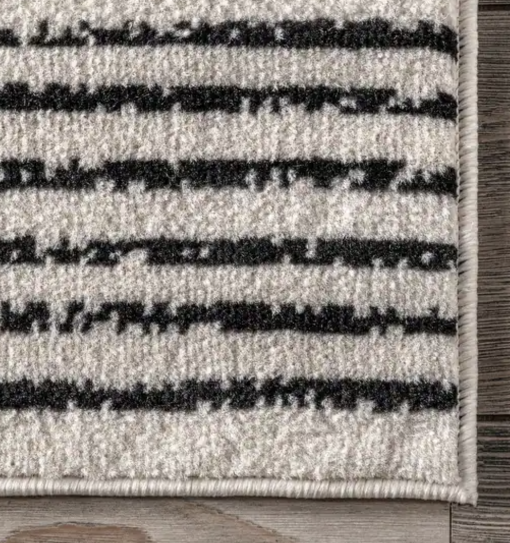 Close up of cream rug with black pinstripes