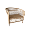 Neutral colored oversized rattan armchair. Intricate cane detailing on back, arms, and legs.