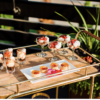 Alden bar cart with a wooden top and gold edging with delicious foods