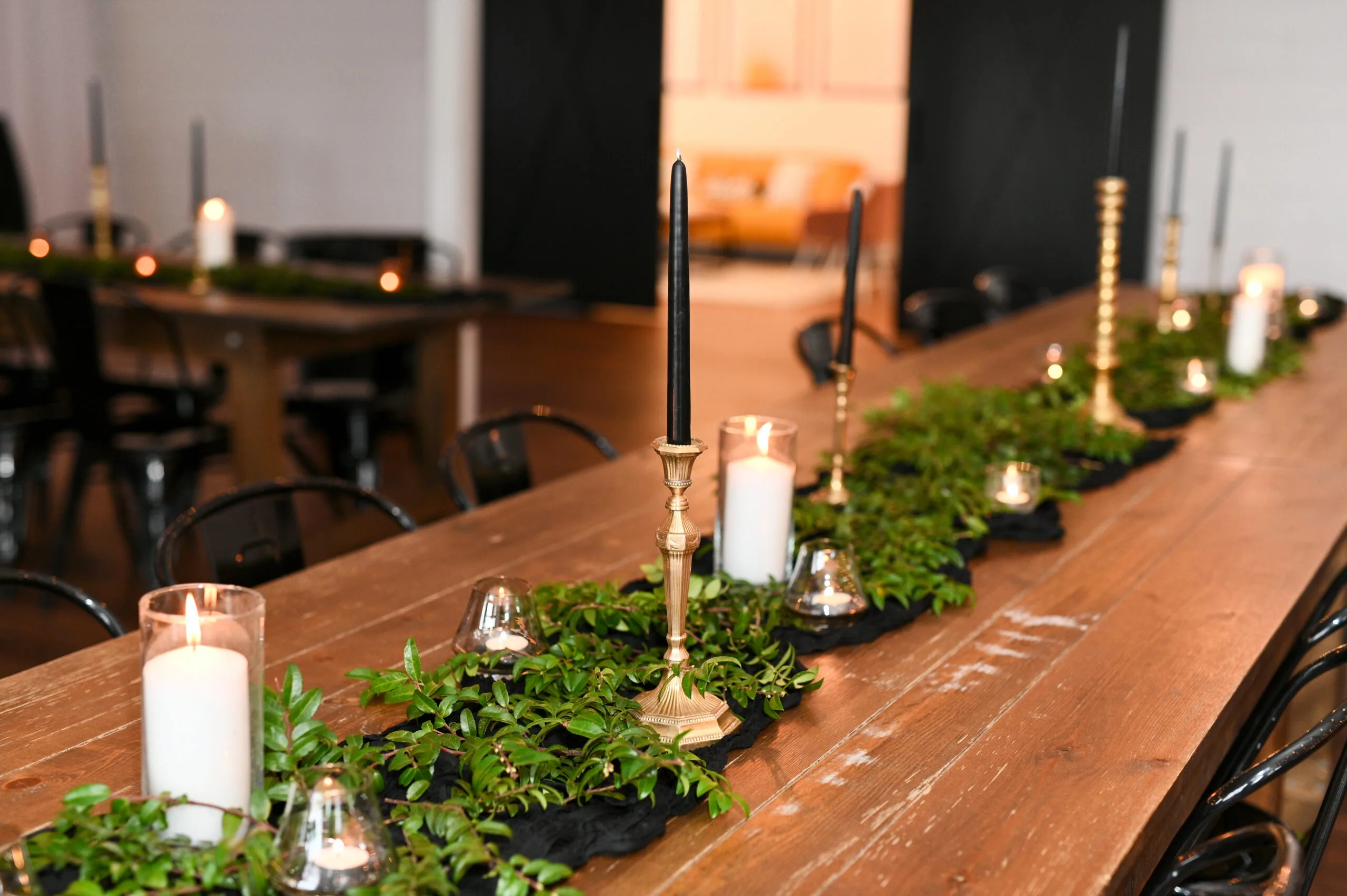 Farm tables with brass candlesticks WEBP wooden farm table with greenery down the middle and votives and brass candlesticks