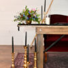 Extra large candlesticks on a rug on the floor in front of a sweetheart table