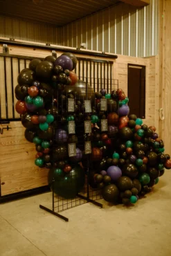 Black metal grid used to display seating chart at wedding reception. Balloon decor behind