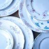 Vintage mismatched colors and patterns of china and plates in various sizes and colors