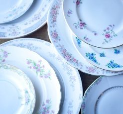 Vintage mismatched colors and patterns of china and plates in various sizes and colors