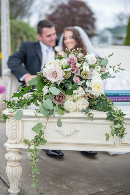 Close up on drawer on the cream coffee table. Florals draping over the side. Couple blurry in the background