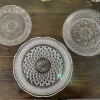 Set of 3 cut glass mismatched plates on a dark wood farm table