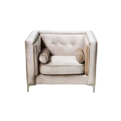Tan velvet chair with buttons on back and small round cylinder pillows.
