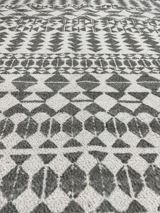 Gray and white rug with close up on the geometric triangles