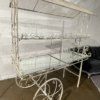 White cart with two tiers and mirrored shelves.