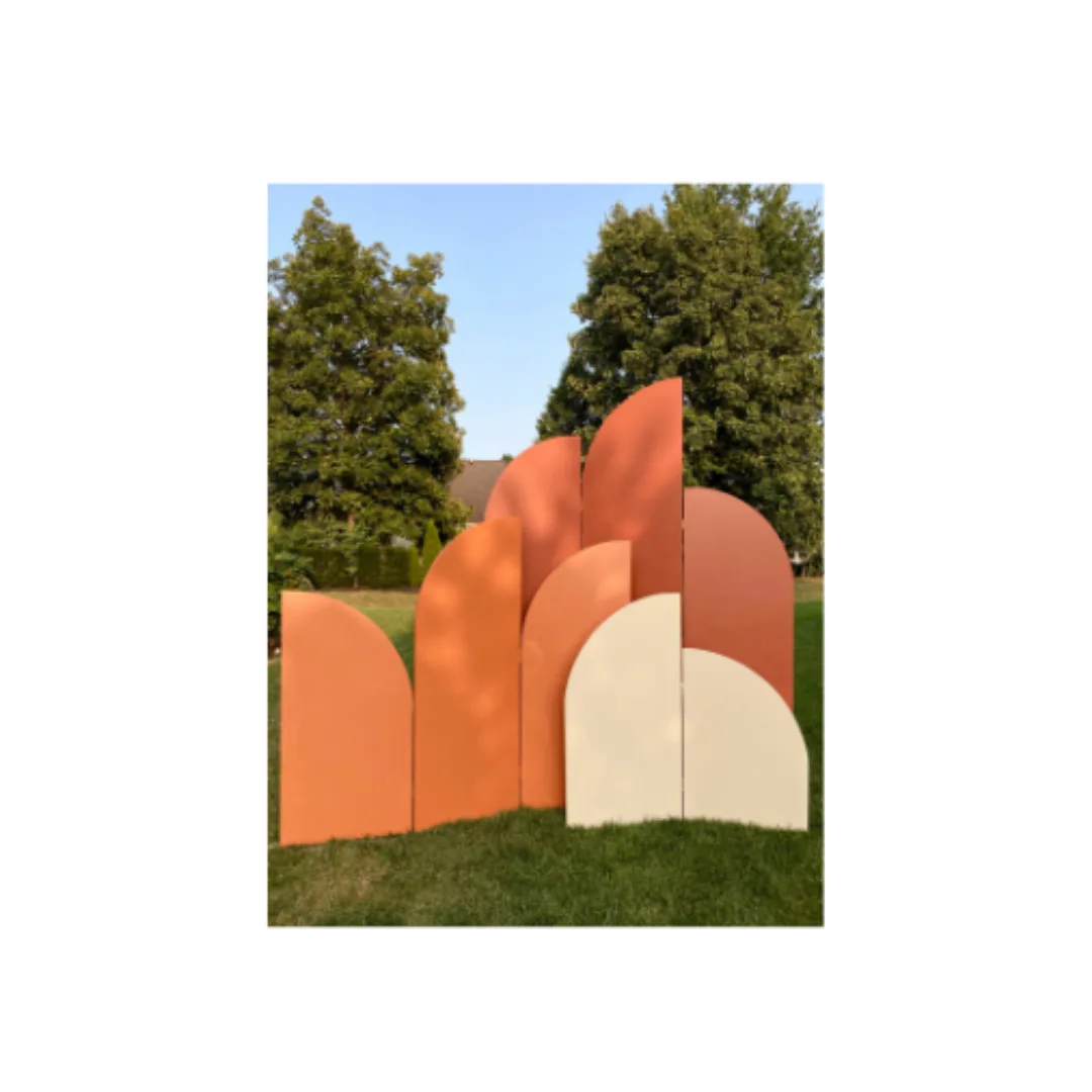 Ezra Panel Backdrop WEBP Small bi-fold panel is 48 inches tall, in the front in cream with round arches. Middle 3-fold panel is 66 inches tall with various curve topped shapes. Rust colored. Final tri-fold panel is 98 inches tall and a burnt orange.