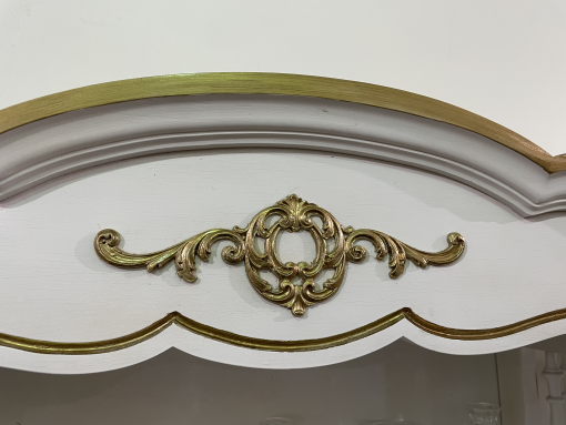 Close up on detail on the dresser. White background with gold design.