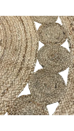Close up of natural jute rug with large braids in the middle and small jute circles on edge