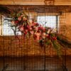 Black wire grid backdrop with florals used in a church wedding ceremony.