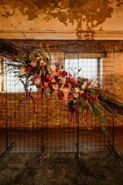 Black wire grid backdrop with florals used in a church wedding ceremony.