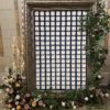 Oversized frame with florals on edges. In the center are seating cards for wedding reception