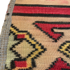 Close up of border area - geometric designs in yellow, blue, red, with black edging.