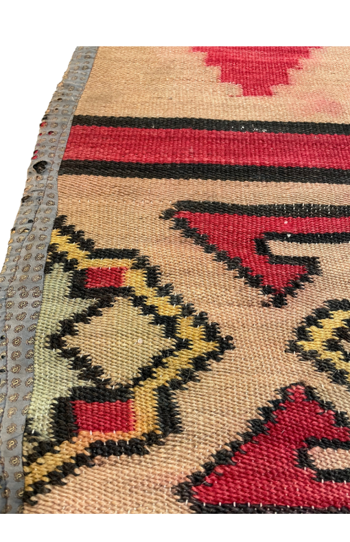 Close up of border area - geometric designs in yellow, blue, red, with black edging.