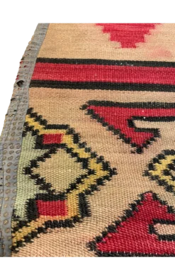 Close up of border area - geometric designs in yellow, blue, red, with black edging.