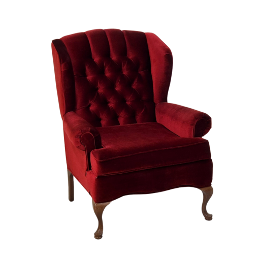 Deep red velvet wing back arm chair. Tufted back with cruved wooden legs.