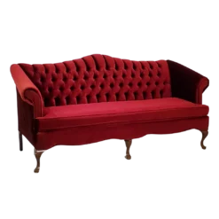 Red velvet sofa, side view. Tufted back, one long cushion. Curved wooden legs