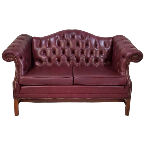 Maroon leather chesterfield sofa with tufted back, two cushions, and winged arms