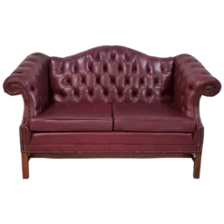 Maroon leather chesterfield sofa with tufted back, two cushions, and winged arms