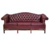 Maroon chesterfield sofa, front view. Button tufted back, wing arms, and 3 cushions.