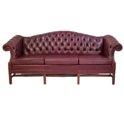 Maroon chesterfield sofa, front view. Button tufted back, wing arms, and 3 cushions.