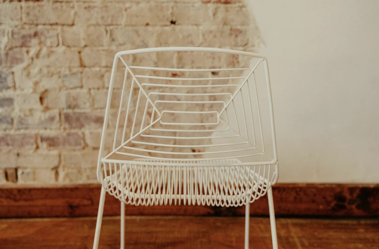 Back close up of white wire modern chair WEBP Consecutively smaller rectangles made of wire