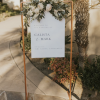 Tall copper stand used to hang a welcome to the wedding sign.