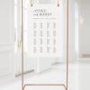 Tall copper stand holding a seating chart at a wedding reception.