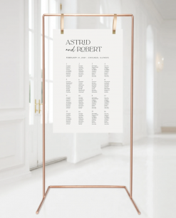 Tall copper stand holding a seating chart at a wedding reception.