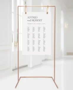 Tall copper stand holding a seating chart at a wedding reception.