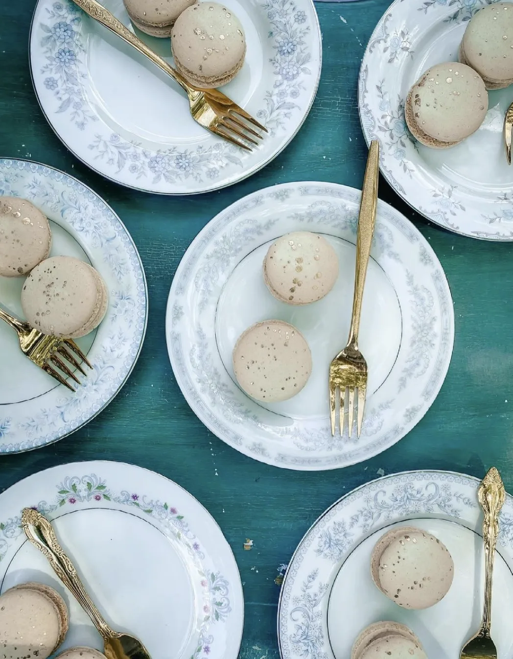 Vintage china plate with gold flatware and dessert WEBP Vintage mismatched china plates with dessert and gold forks.
