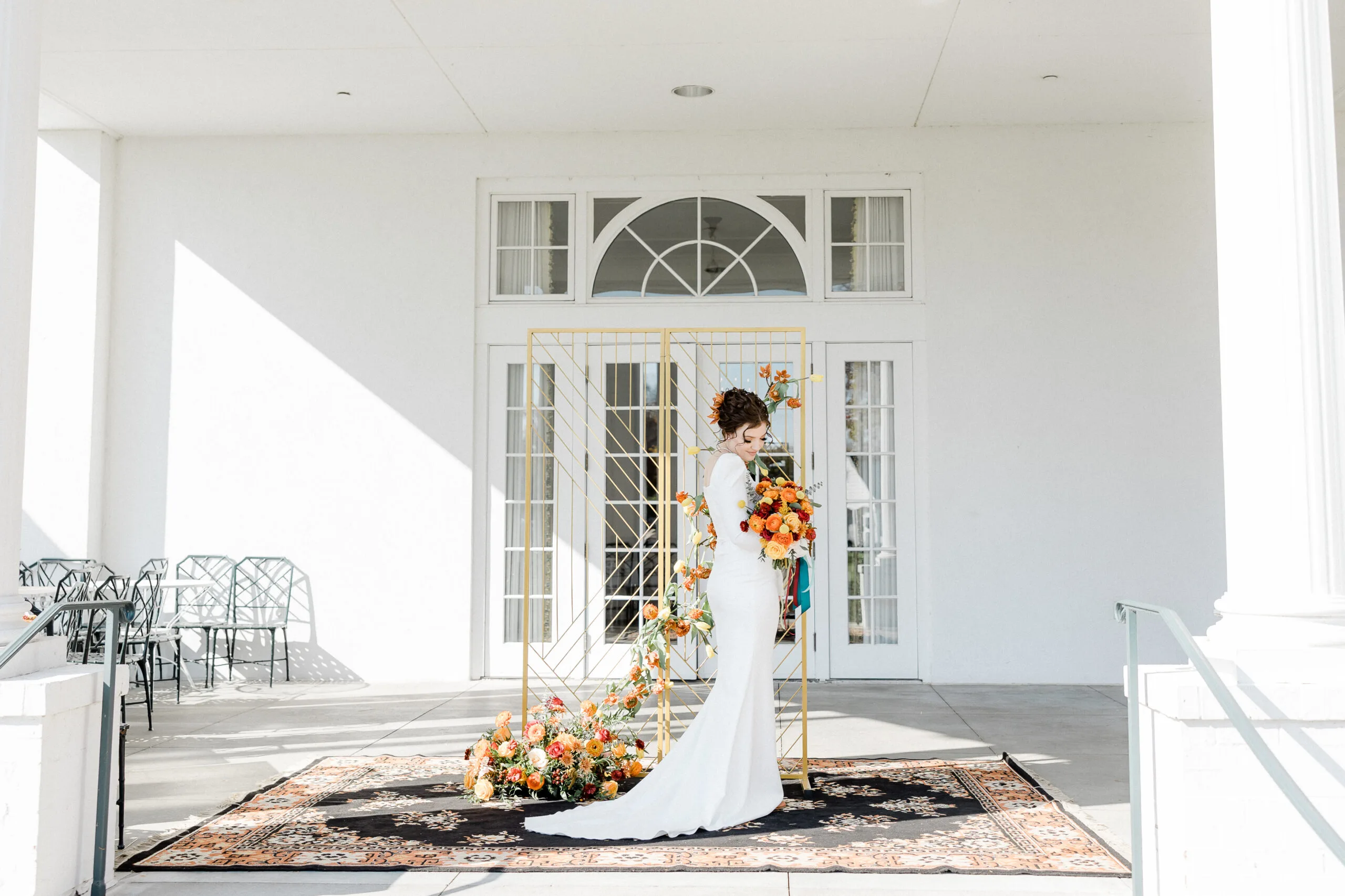 Wedding Phoro shoot WEBP Bride standing on a large ornate rug with a gold backdrop posing for wedding photos