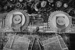 Black and white arial photo of a sweetheart table at a wedding reception. Boho tablescape and white wire modern chairs
